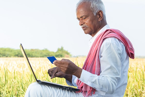 Indian farmer on laptop making a payment