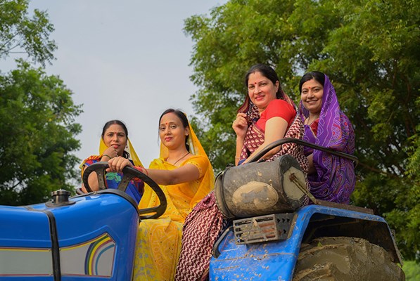 Women in India sitting on a tractor