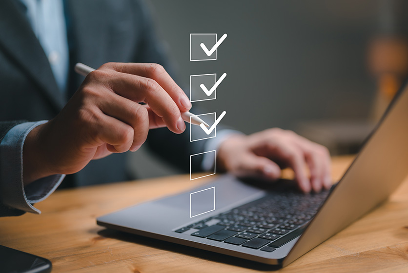 Businessman using a laptop showing a performance checklist